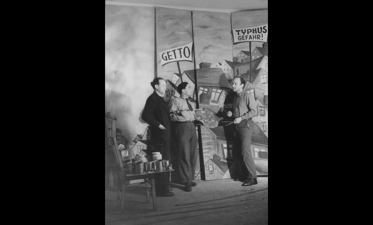 Two theatre groups were created in Belsen: the Kazet-Theatre (Concentration Camp Theatre) and the Yidisher Arbeter-Bine (Yiddish Workers’ Stage). The Kazet group they staged their first production on 6 September 1945. Samy Feder, the director of the Kazet group, recalled years later, ‘I have never played to such a grateful audience. They clapped and laughed and cried.’ The theatre groups often staged famous pre-war Yiddish plays, such as those by the famous Yiddish author and playwright Sholem Aleichem. Various ORT programs helped with the productions, sewing costumes and building sets. 

 
